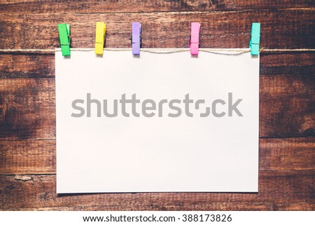 Paper attach to rope with clothes pins on wooden background