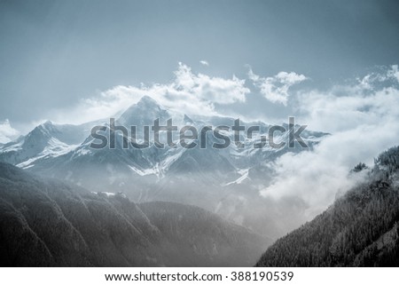 bluish-colored black and white image of a wind storm in the alps