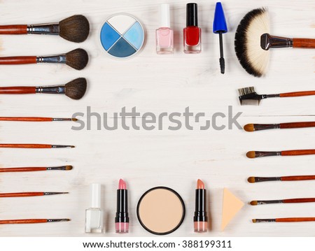Various makeup products on white wooden background with copyspace