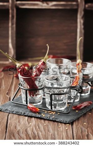 Glasses of vodka with hot chili peppers, selective focus