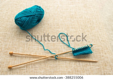 Turquoise yarn and knitting needles, background concept and copy space.