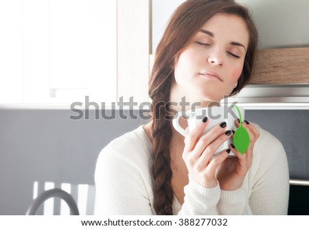 Woman with cup of tea in modern kitchen