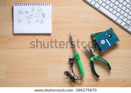 Top view of repair tool,hard disk and notepad on wood table.