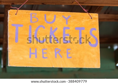 Handmade sign reads "Buy Tickets Here" at grassroots carnival.