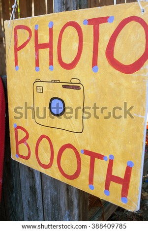 Handmade sign reads "Photo Booth" at grassroots carnival.