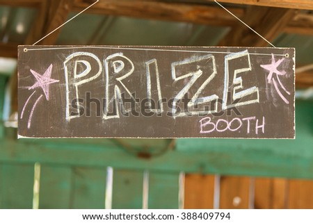 Handmade sign reads "Prize Booth" at grassroots carnival.