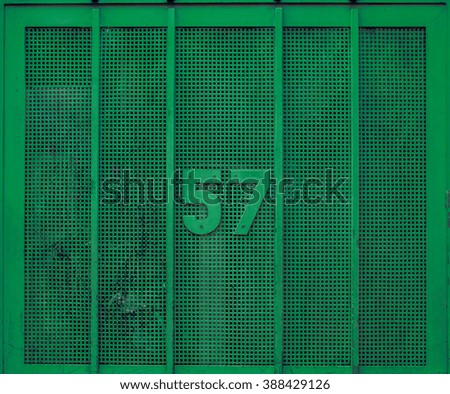 Green metal gate door with number.
