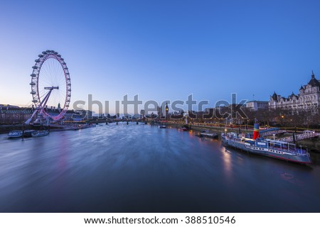 Skyline of London before sunrise with famous landmarks, Big Ben, Houses of Parliament, boat and clear blue sky - England, UK