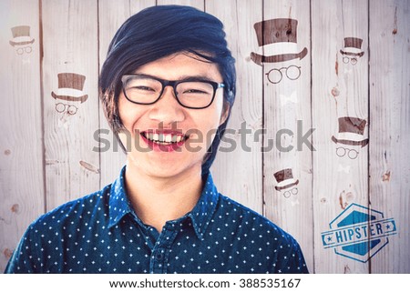 Smiling hipster businessman looking at camera against wooden background