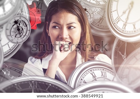 Businesswoman biting her fist against black background
