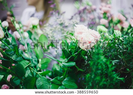 Florist workplace: flowers and accessories. pretty bouquet in a basket on a background of flowers and accessories. soft focus