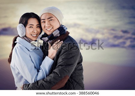 Portrait of couple embracing against beautiful beach on a sunny day