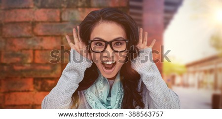 Asian woman shouting to the camera against view of brick wall