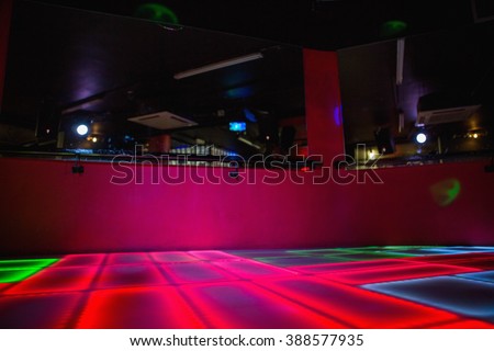 Red illuminated disco dance floor in bar