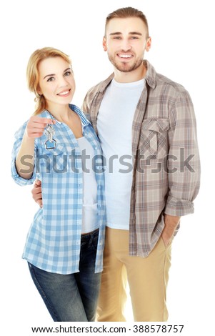 Happy young couple with keys from new house isolated on white