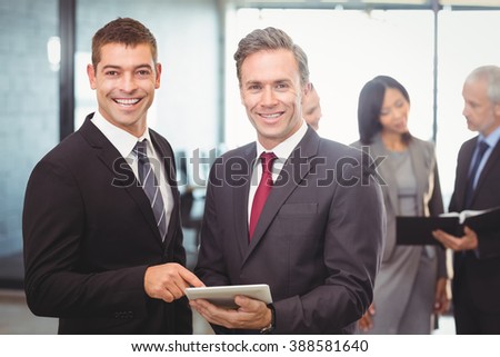 Portrait of businessmen using digital tablet in office