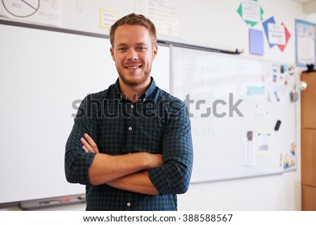 Portrait of confident Caucasian male teacher in classroom Royalty-Free Stock Photo #388588567