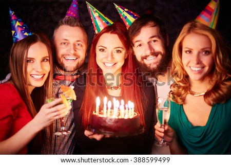 Portrait of cheerful friends with birthday cake