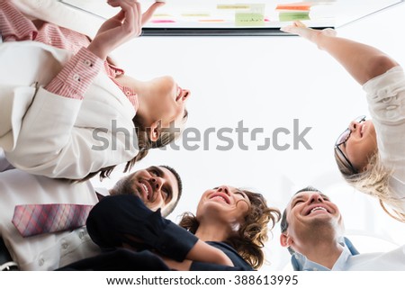 Group of business people in office at creative brainstorming at board, low angle Royalty-Free Stock Photo #388613995