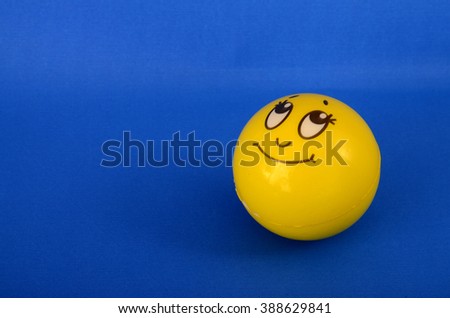 yellow smiley  toy ball on blue