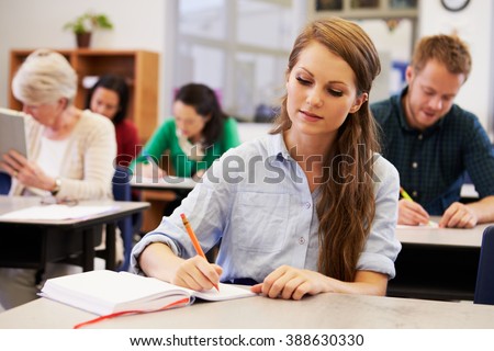 Young woman studying at an adult education class Royalty-Free Stock Photo #388630330