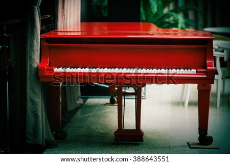 Beautiful red grand piano indoor Royalty-Free Stock Photo #388643551