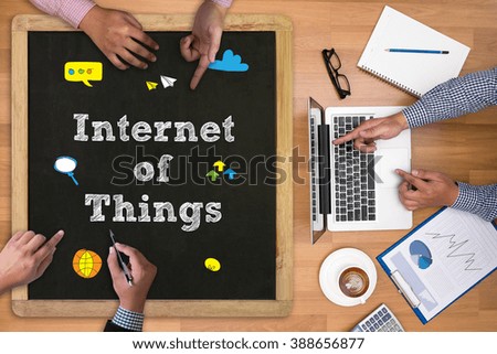 Businessman working at office desk and using computer and objects on the right, coffee,  top view, business man hand working and internet of things (IoT) word diagram as concept