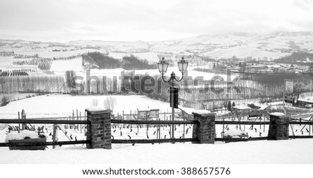 Panorama of the world famous Barolo vineyards in wintertime, full covered by the snow (Langhe, UNESCO World Heritage Site, Piedmont Northern Italy). Black and white photo.