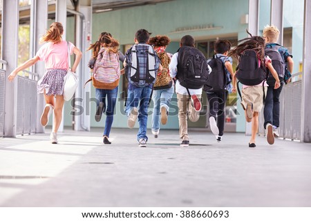 Group of elementary school kids running at school, back view Royalty-Free Stock Photo #388660693