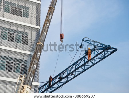 Construction workers standing on crane and working for his job.