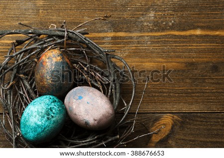 Easter eggs in the nest on wooden background.Rustic style. Top view. Free space for text.