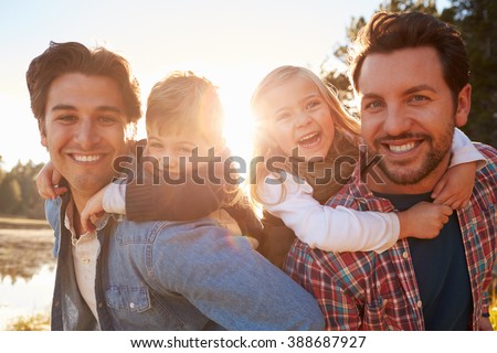 Gay Male Couple With Children Walking By Lake Royalty-Free Stock Photo #388687927