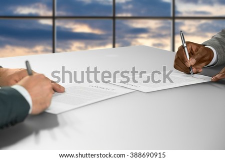 Businessmen sign contracts at sunset. Managers signing papers at work. Starting partnership at headquarters. Benefits are tangible.