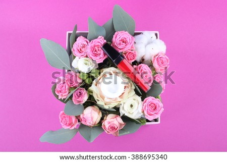 cosmetic, creams, lipstick with\on fresh rose flowers on pink table