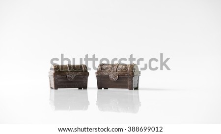 Plastic pirate treasure chest with golden coins. Isolated on white background. Slightly de-focused and close-up shot. Copy space.