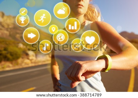 Exercising Woman Checking Activity Tracker With Health Icons Royalty-Free Stock Photo #388714789
