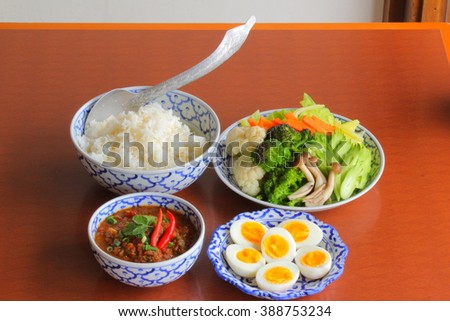 Naam Prik Pla Ra. Thai chili dipping with streamed vegetable and boiled Eggs served with streamed Jasmine rice. picture are took on table wood and selective focus. 