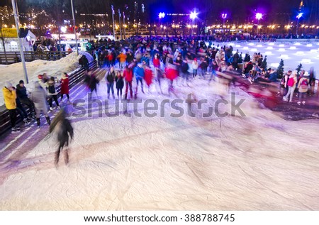 People are having fun enjoying life while skating in the park at the winter ice rink at night