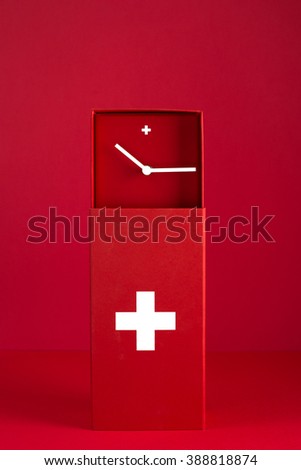 a Swiss clock in the colors of the national flag on a red background, vertical frame