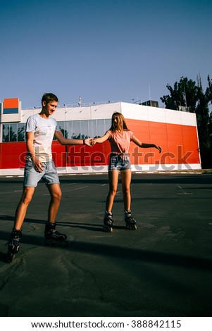 beautiful couple in love roller-skating in the parking lot at sunset