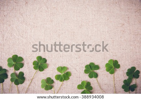 Fresh clovers leaves on linen, St Patricks day copy space background