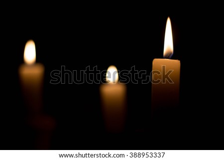 Candle on dark background. Candle in low key. Candle flame at night closeup.