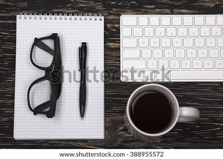 Opened notebook, glasses ,mug , modern computer keyboard
