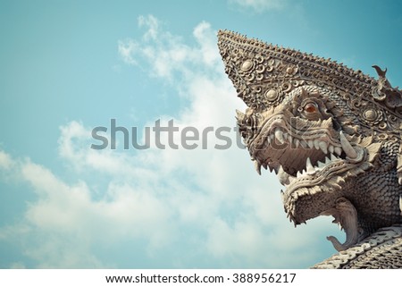 Serpent or naga statue head with blue sky background , process in vintage style