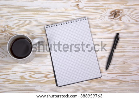 notebook with pen and mug  on wooden table