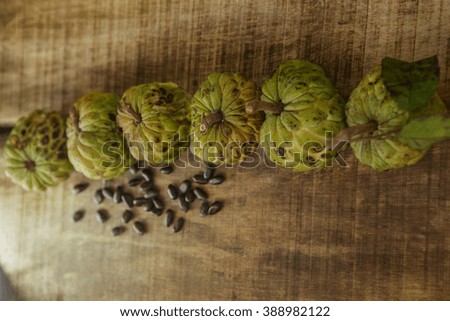 top view row from green ripe sugar-apples on wooden table background