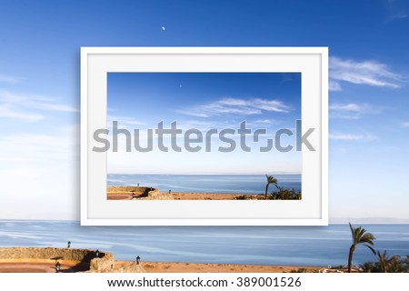 Photo frame with sea view poster on blue sky wallpaper. Interior decor conception