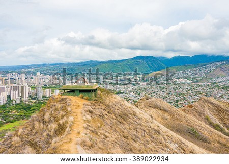 Top of the diamond head crater with an old buildings on the top and the city of Honolulu on the background.