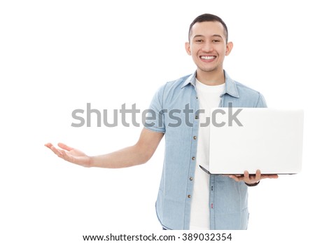 portrait of handsome young man holding a laptop while presenting copy space isolated on white background