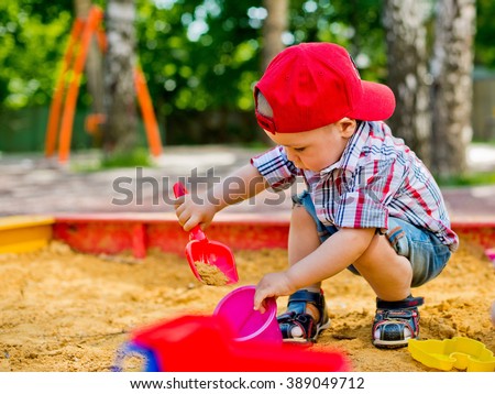 child plays with sand  Royalty-Free Stock Photo #389049712